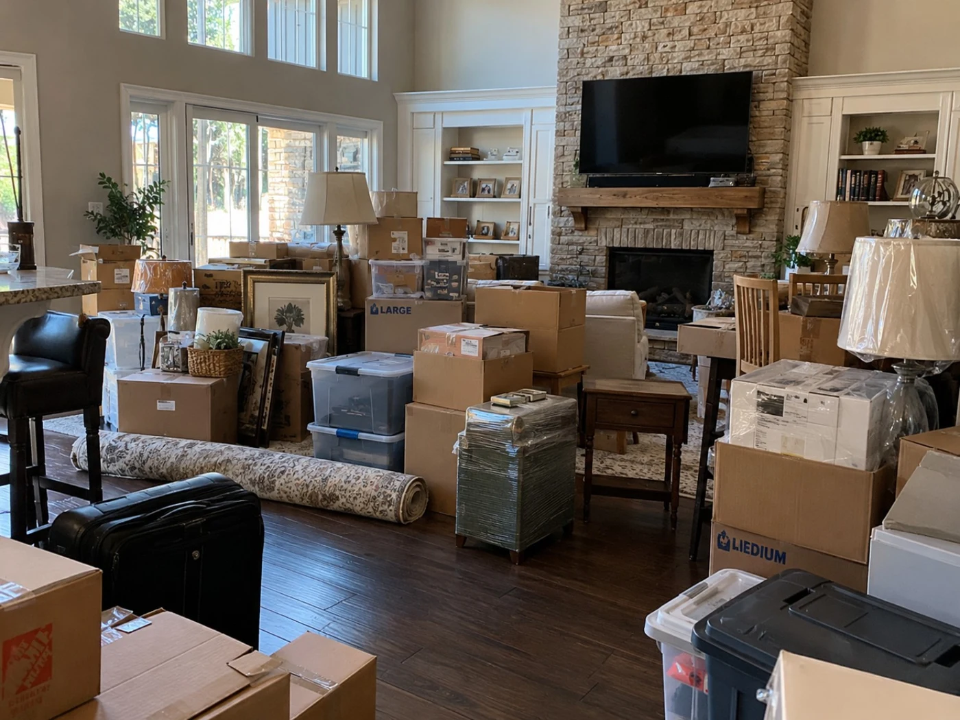 Living area with boxes and packed belongings before unpacking in Addison