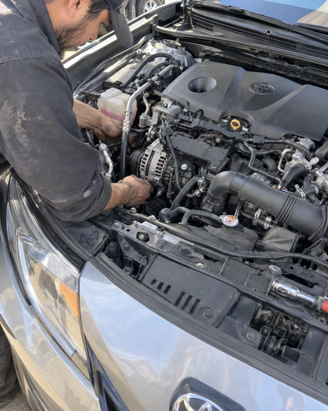 BlueStar working under the hood of a Toyota Camry during alternator replacement in Fort Worth