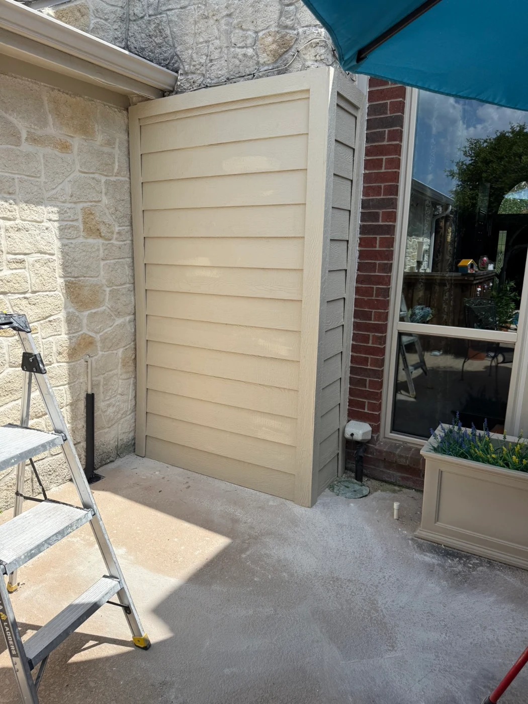 Siding covering the stone wall beside the patio window in Plano
