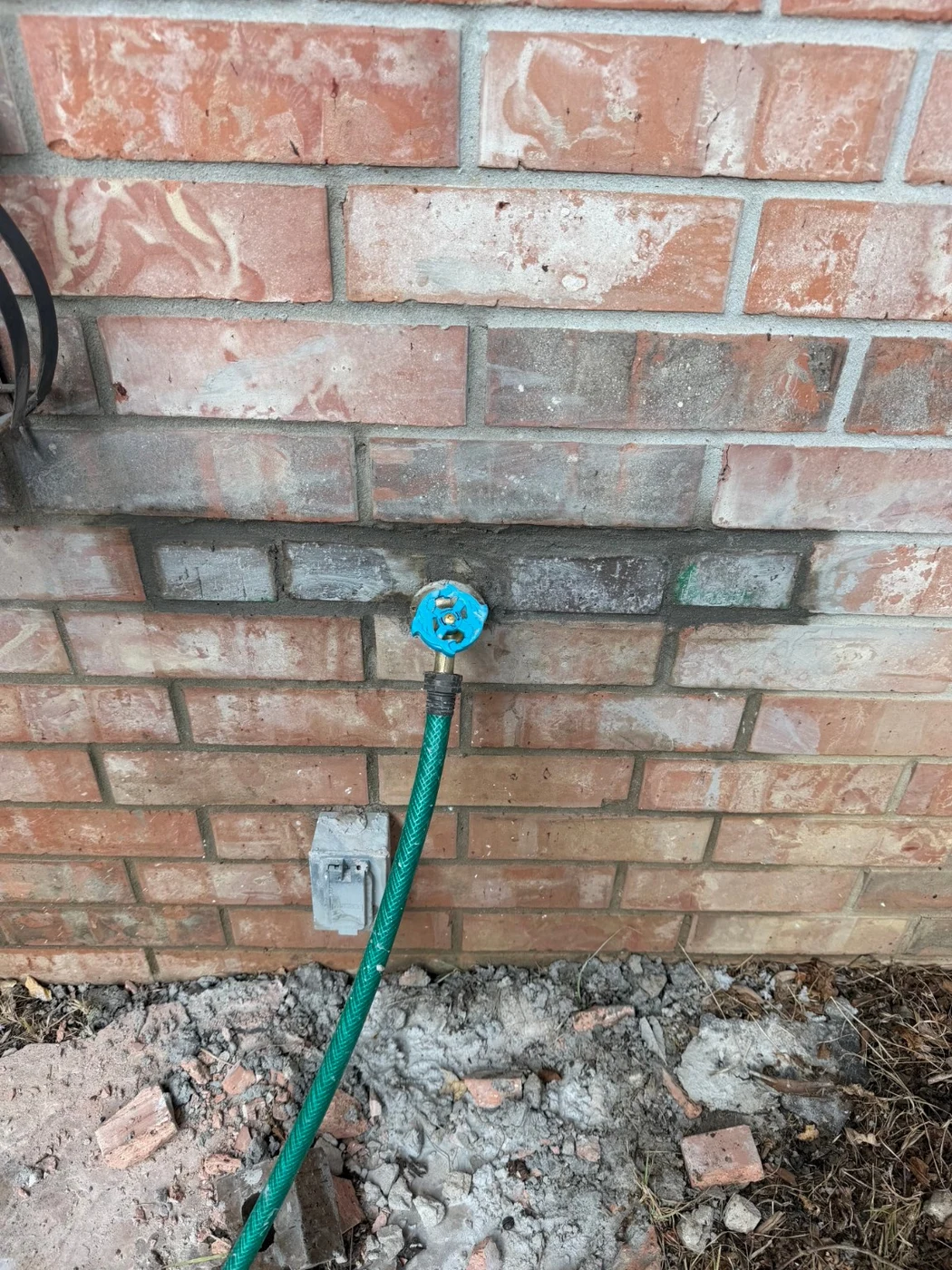 Exterior faucet and closed brick opening after the pipe repair in Waxahachie