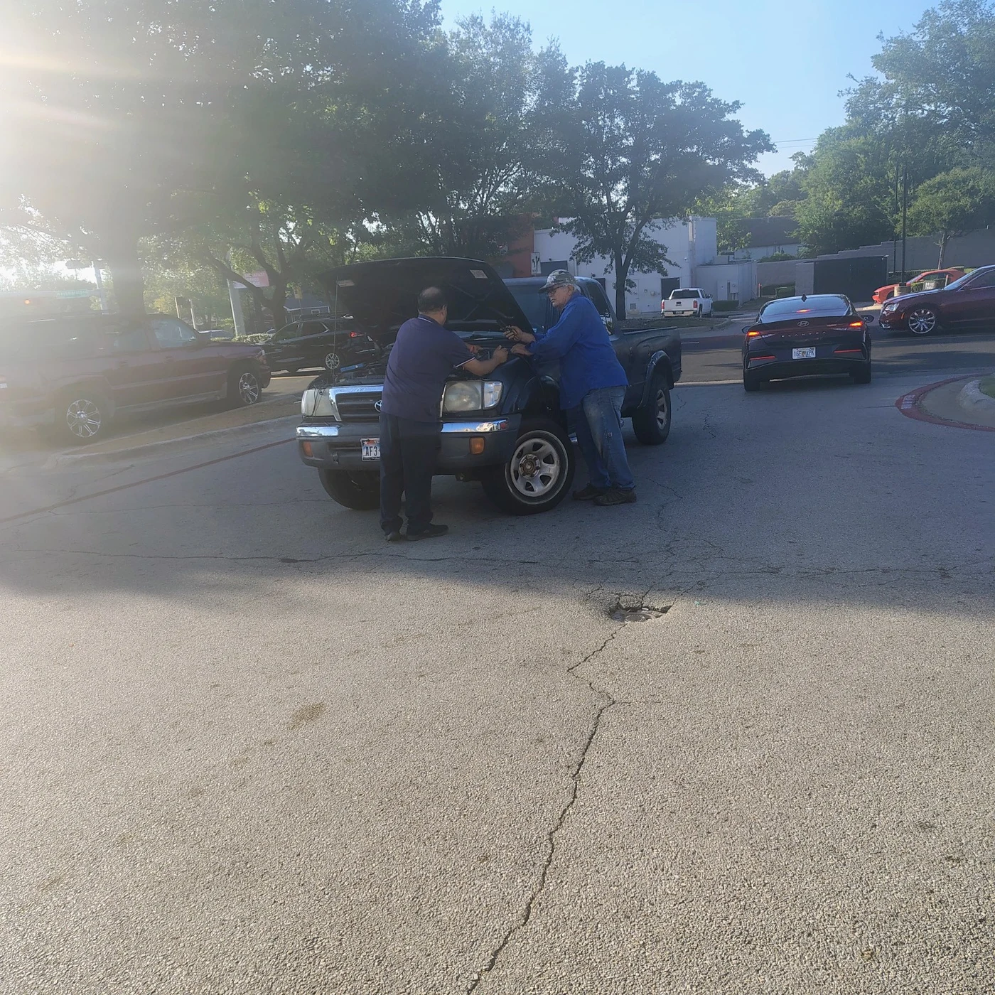 Stalled vehicle in a West Oak Cliff parking lot before roadside help